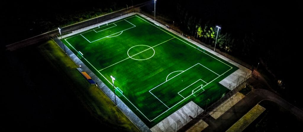 Jalgpalliväljaku kunstmuru öösel valgustatuna
