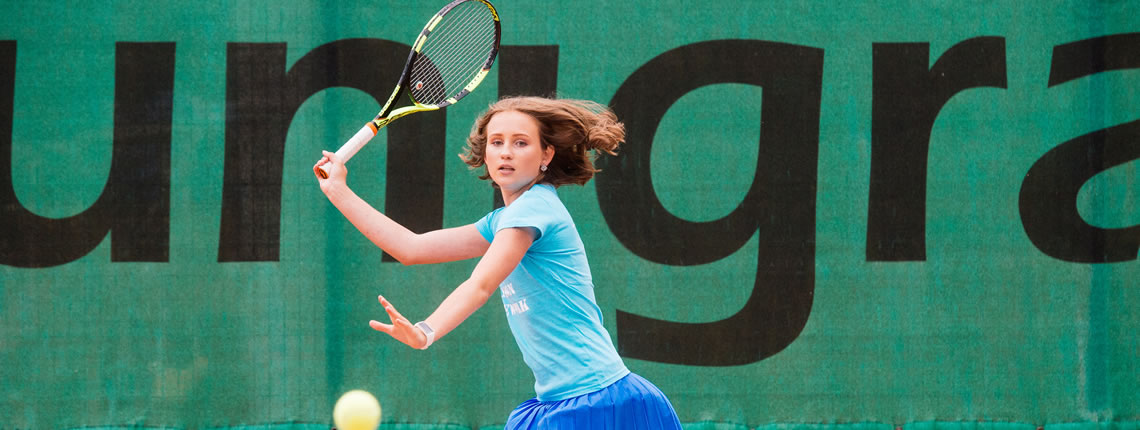 Unigrass kontakt Tüdruk mängib tennis Unigrassi tuuletõkke fooni ees