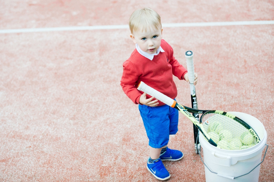 Poiss tennisereketite ja pallidega